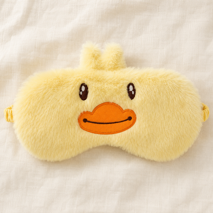 Cute animal sleep eye mask in soft plush - lifestyle view on a bed